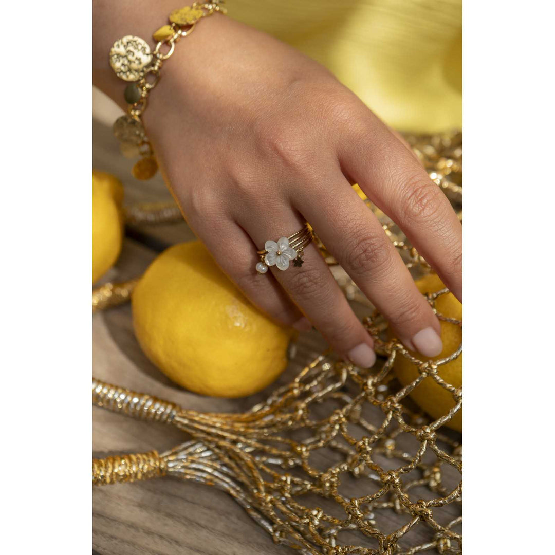 Bague dorée en acier inoxydable avec fleur blanche portée, perle dorée et breloques, réglable et résistante à l’eau