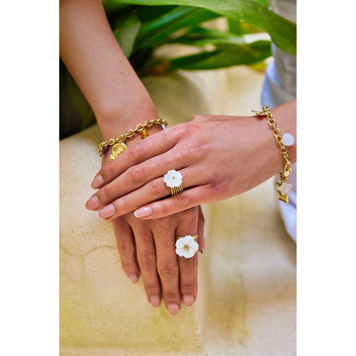 Mains portant des bagues dorées avec fleurs en nacre blanche, bijoux en acier inoxydable hypoallergéniques, résistants à l'eau et ne noircissant pas