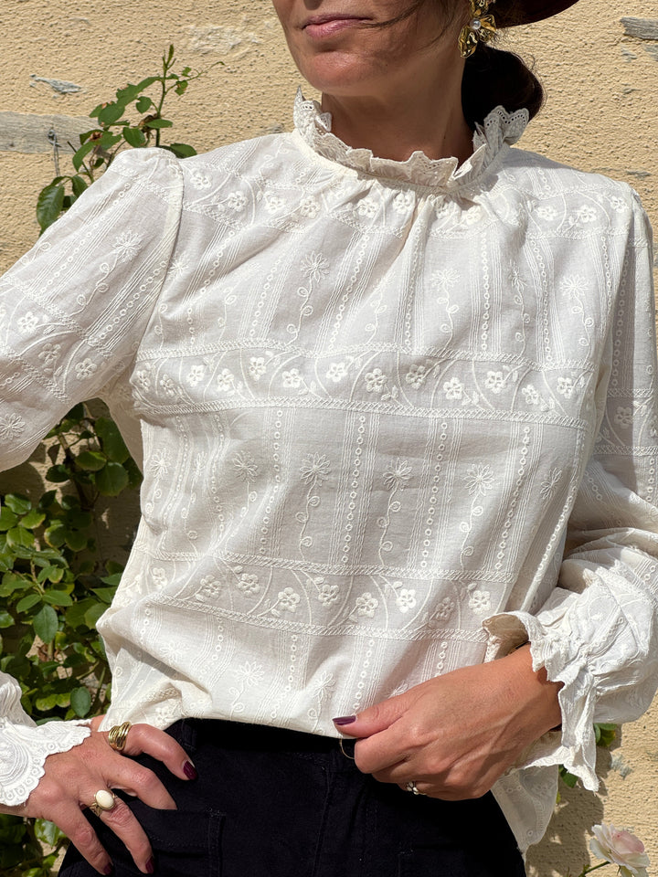 Blouse GUSTIN In April 1986 beige écru à broderies florales ton sur ton, col montant volanté et manches longues pour femme.