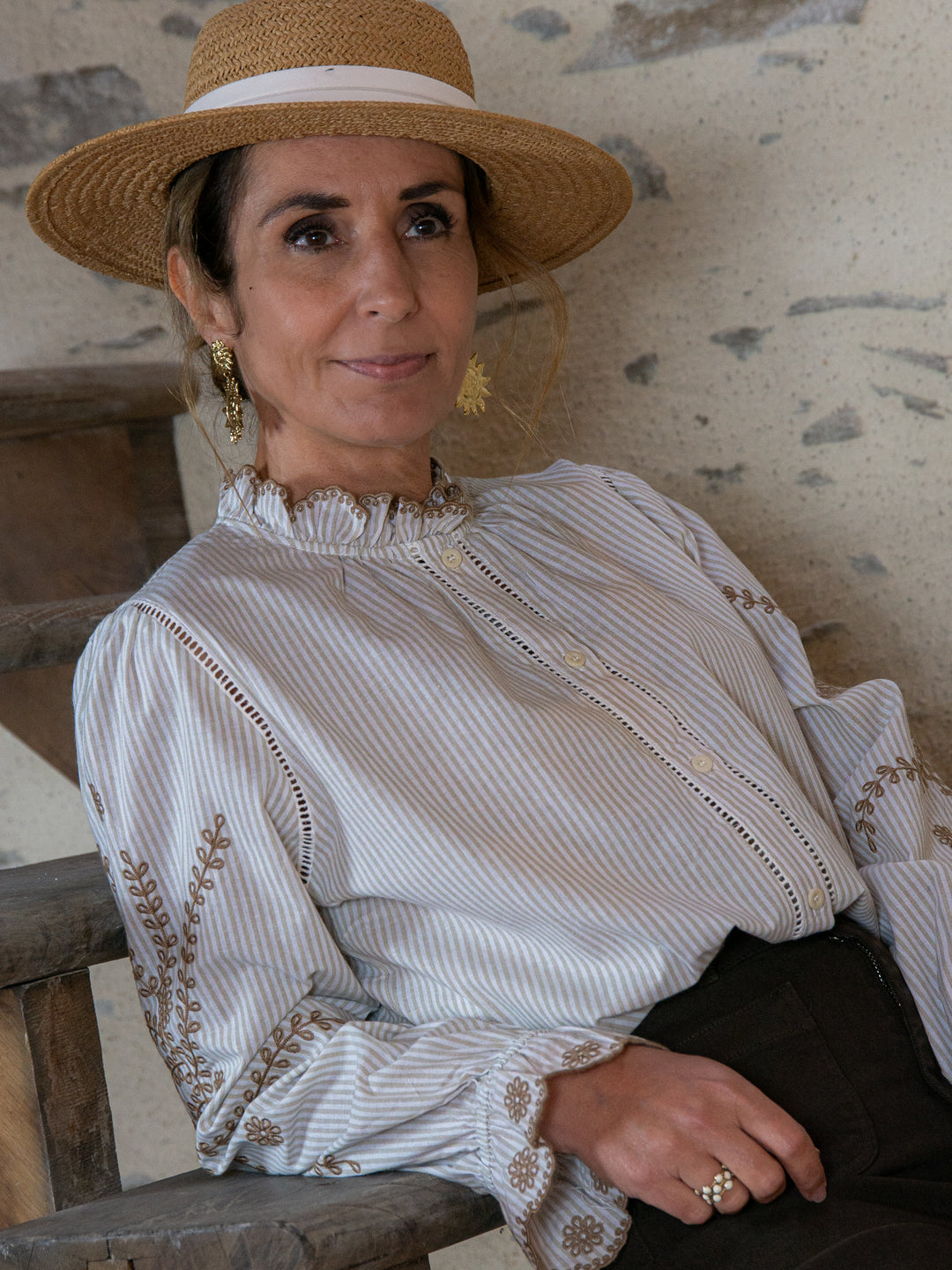 Blouse femme rayée avec manches brodées camel, style bohème chic assise sur un escalier