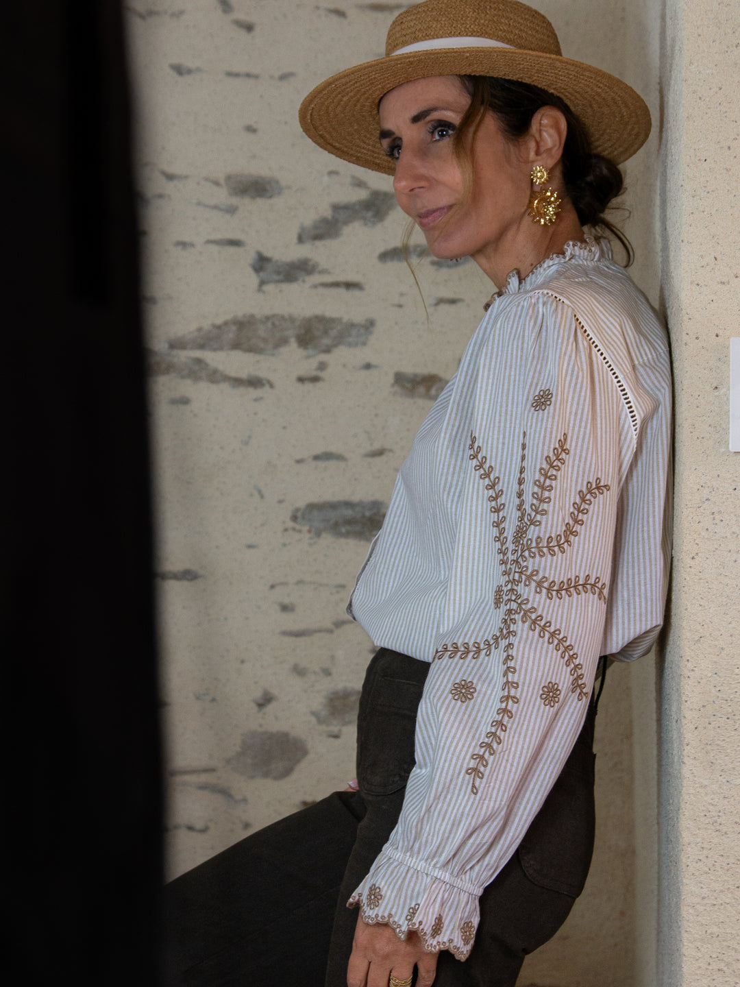 Blouse rayée femme avec broderies camel portée avec un chapeau en paille – look élégant
