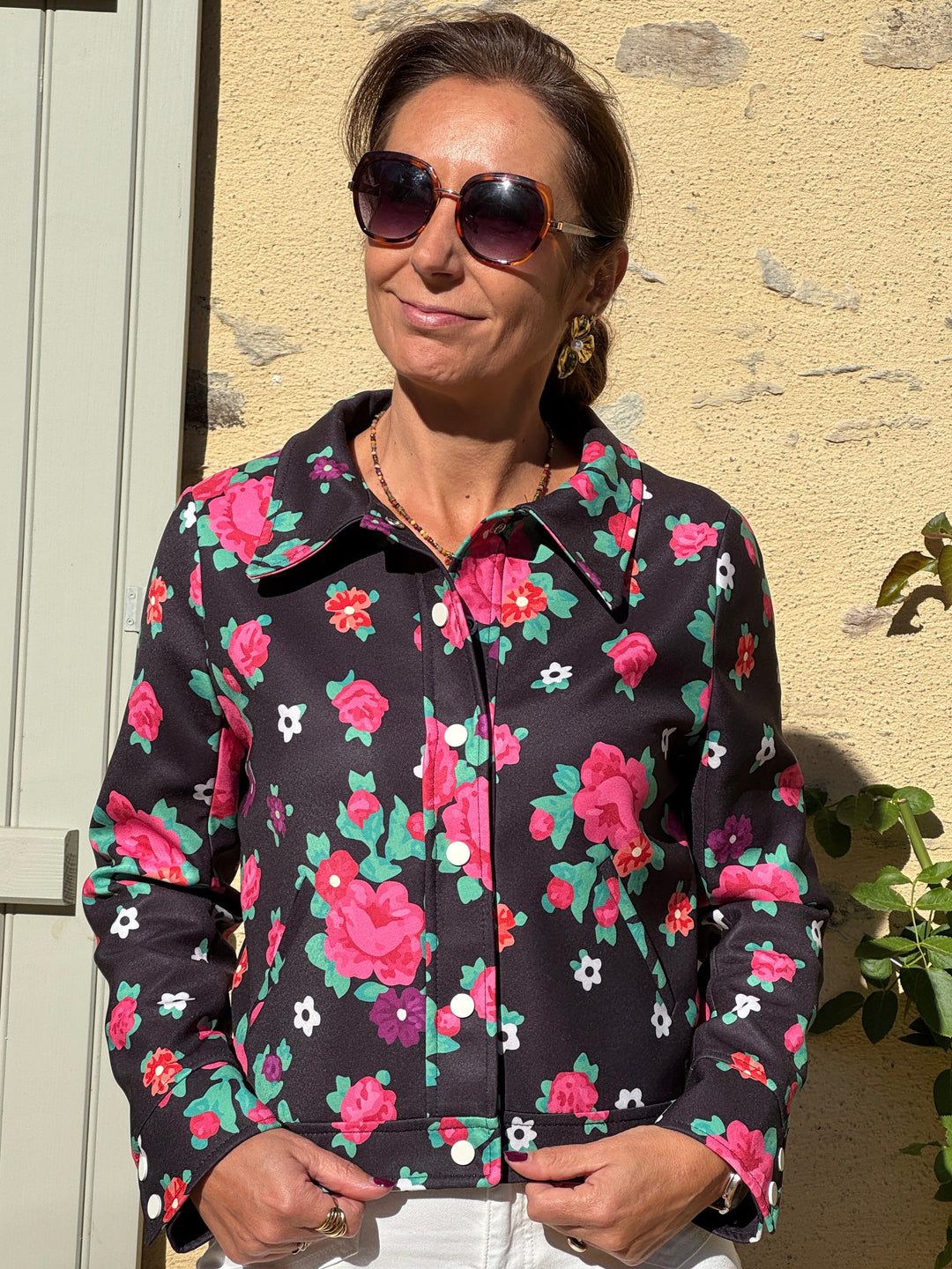 Blouson SEVENTIES n°187 Hippocampe pour femme à imprimé floral rose, rouge et vert sur fond noir, col large et boutons blancs.