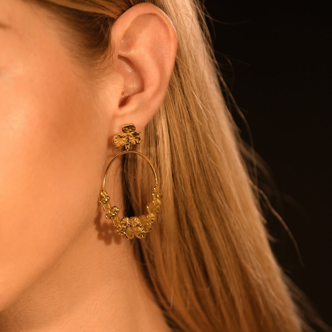 Boucles d’oreilles dorées portées, anneaux décorés de fleurs élégantes, bijou tendance hypoallergénique