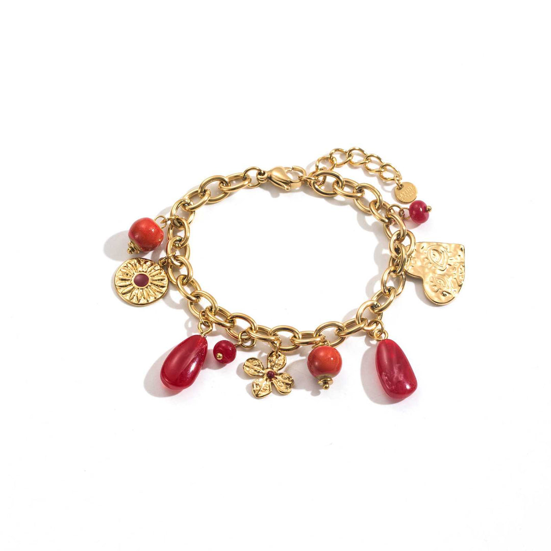 Bracelet chaîne dorée avec plusieurs charms rouges
