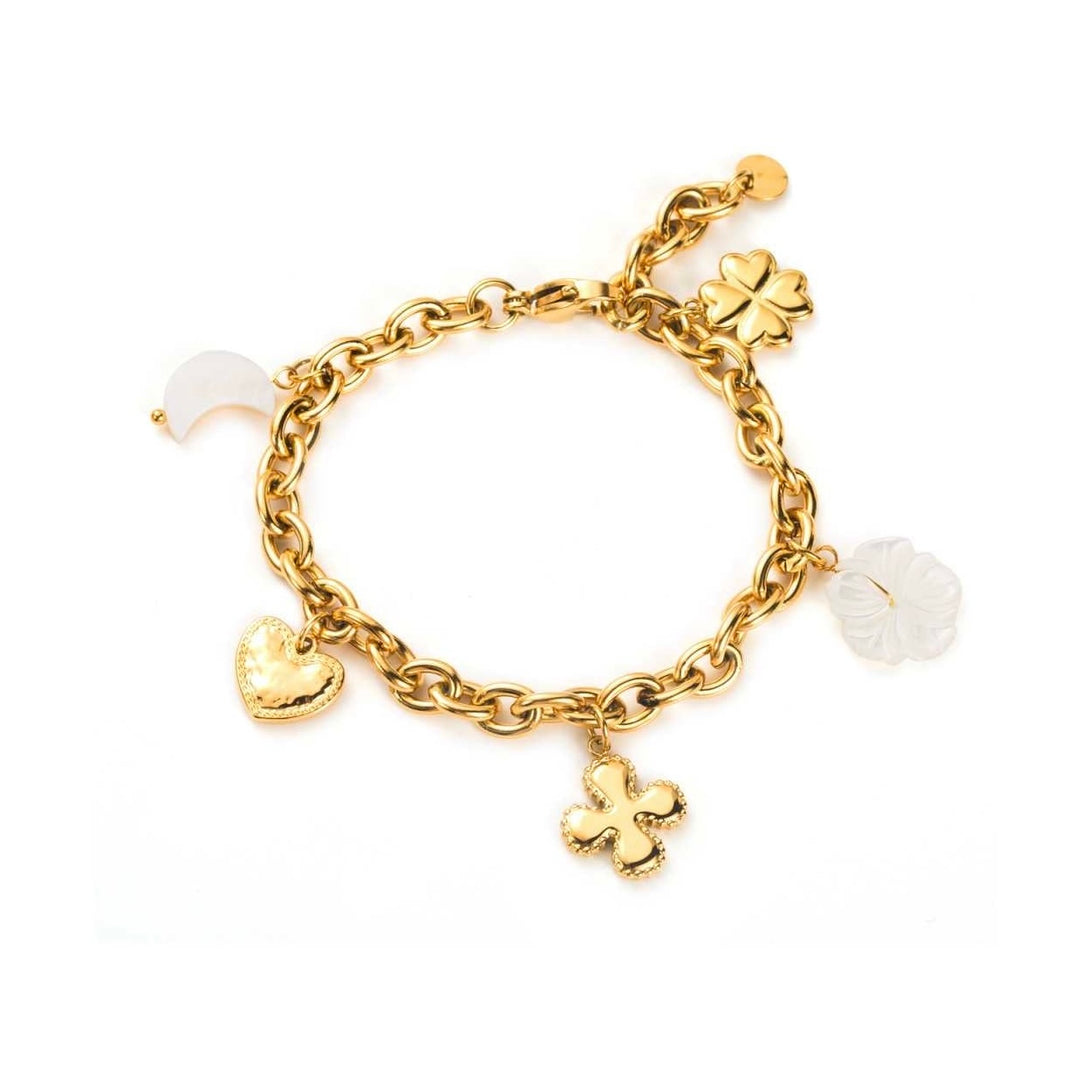 Bracelet doré à charms avec pendentifs fleur, cœur et demi-lune blanche porté au poignet