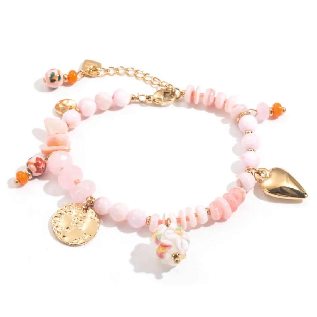Bracelet charms rose et doré en acier inoxydable avec perles roses pastel et pendentifs fantaisie, bijou femme bohème chic.