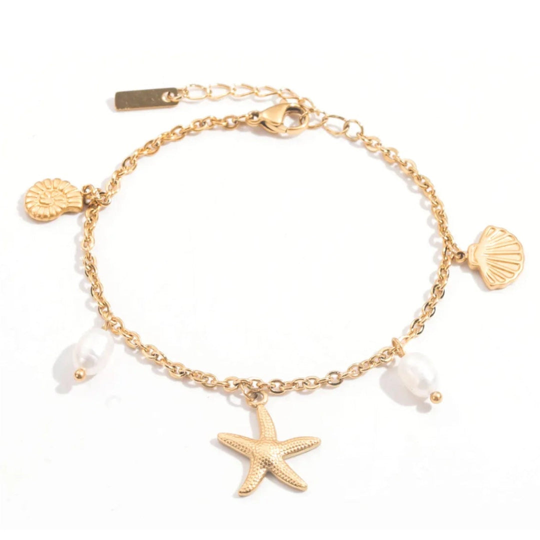 Bracelet doré en acier inoxydable avec étoile de mer, coquillages et perles blanches, bijou femme style marin chic et tendance.