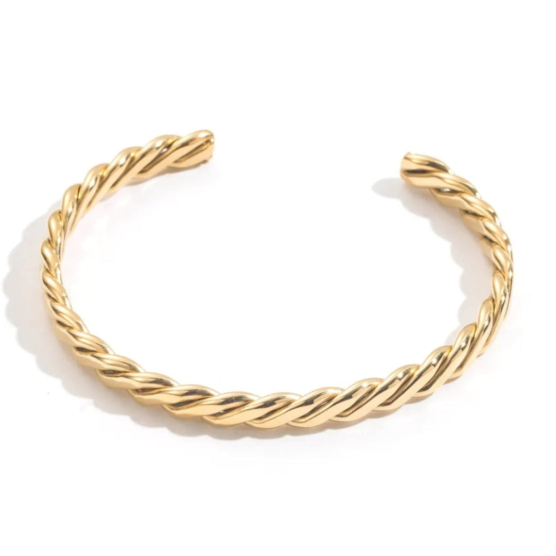 Bracelet jonc torsadé doré en acier inoxydable pour femme, bijou minimaliste chic et élégant.