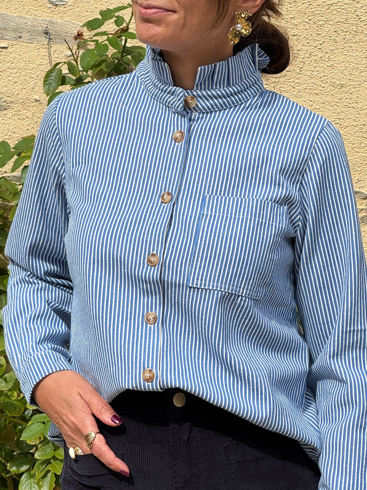 Chemise CHARLIE In April 1986 à rayures tennis bleues sur fond blanc, col montant volanté, manches longues et poche poitrine.