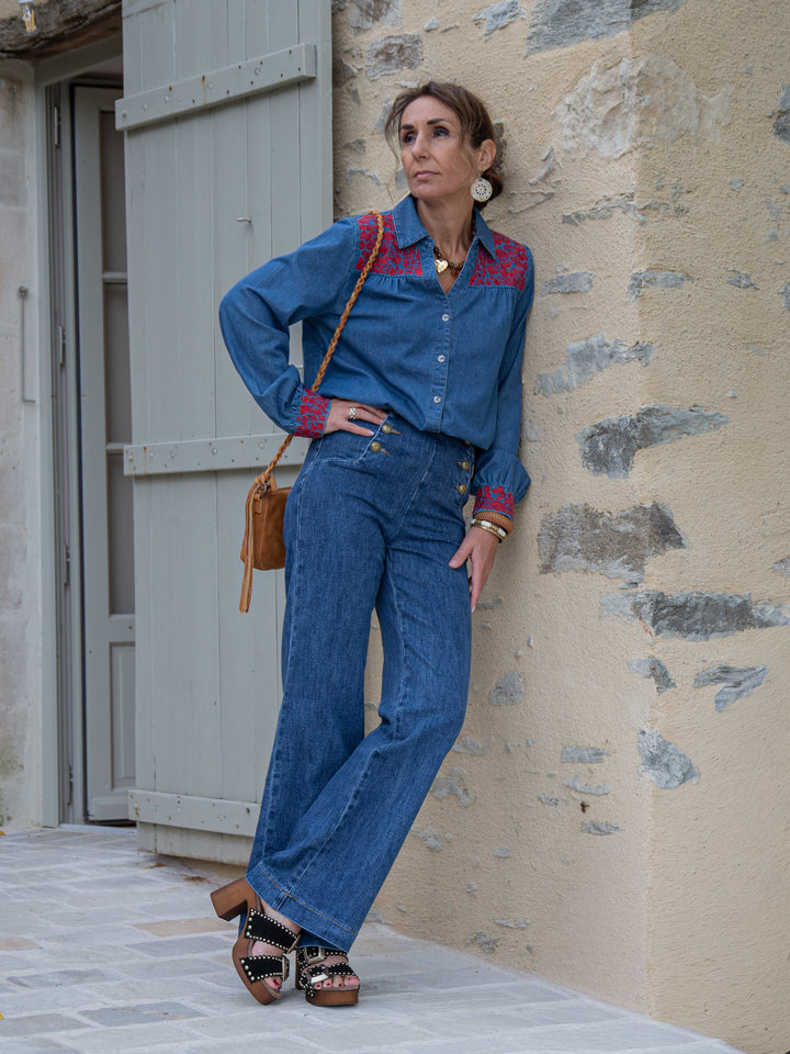 femme en tenue denim avec chemise en jean brodée rouge et jean taille haute, look bohème