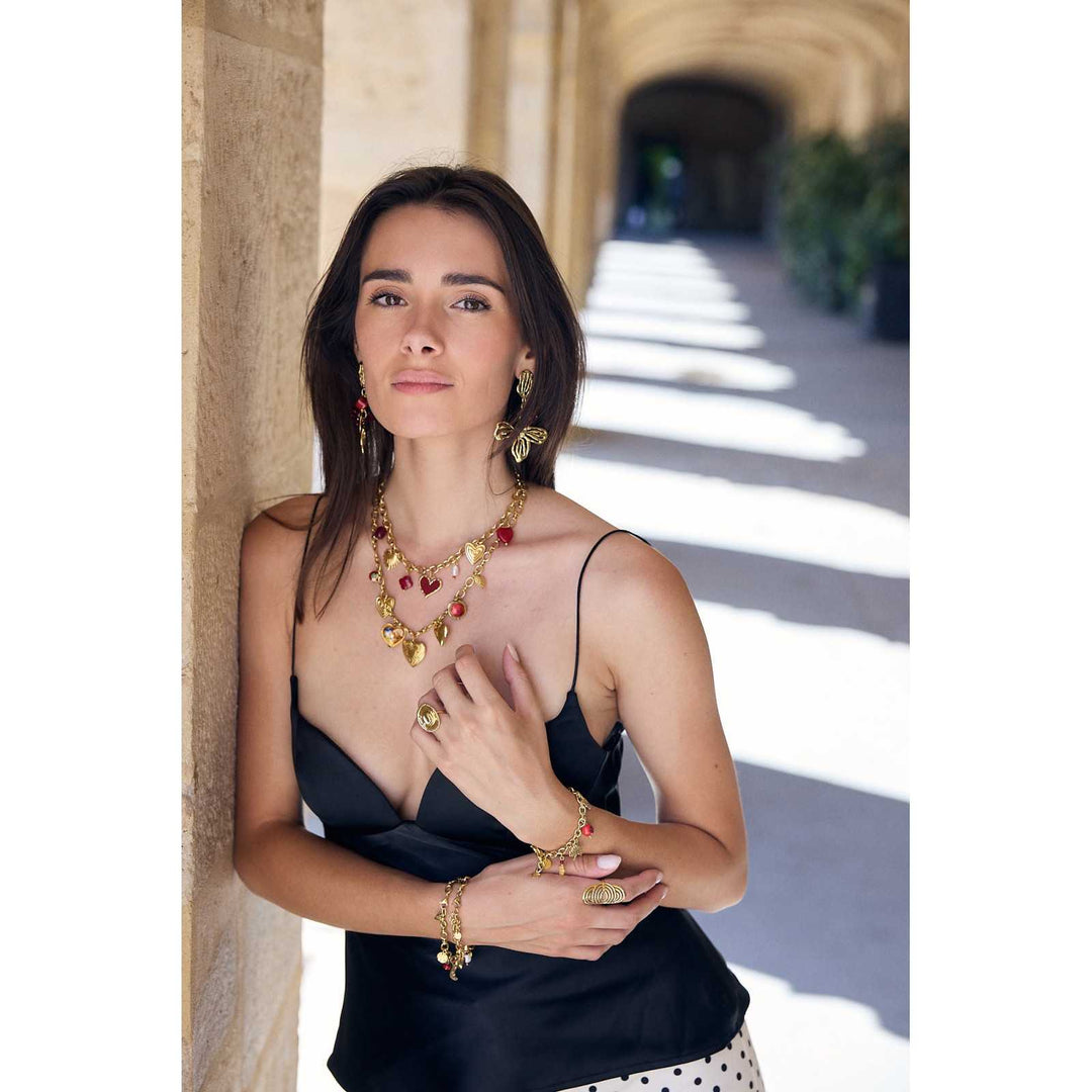 Femme portant un collier multicœur doré et bordeaux en acier inoxydable – bijou réglable, hypoallergénique et résistant à l’eau