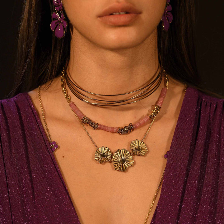 Femme portant un collier triple coquillage doré en acier inoxydable – bijou tendance, hypoallergénique et résistant à l'eau