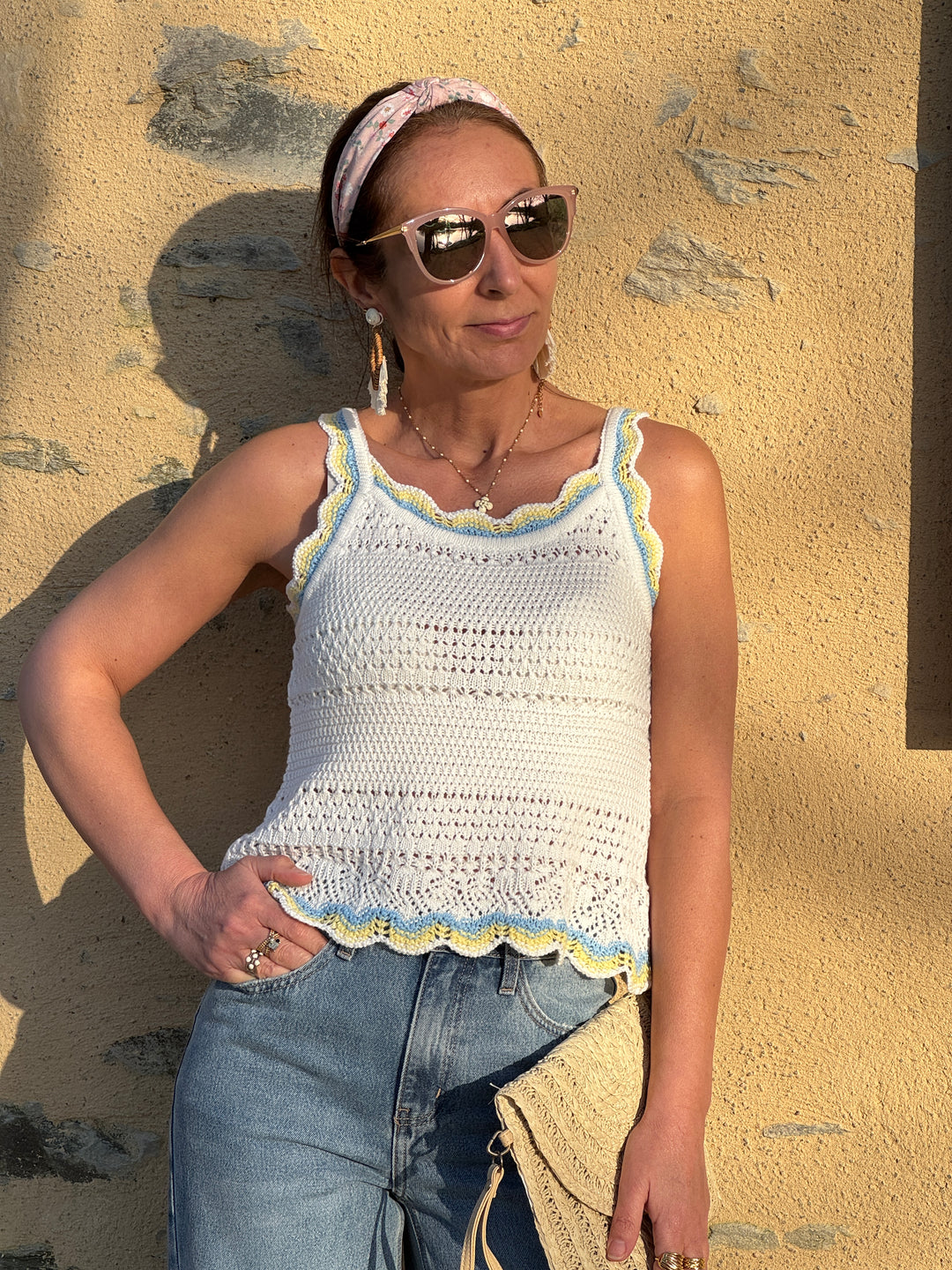 Débardeur crochet ajouré blanc avec détails jaune et bleu ciel, style bohème à bretelles épaisses et coupe confortable idéal pour l’été