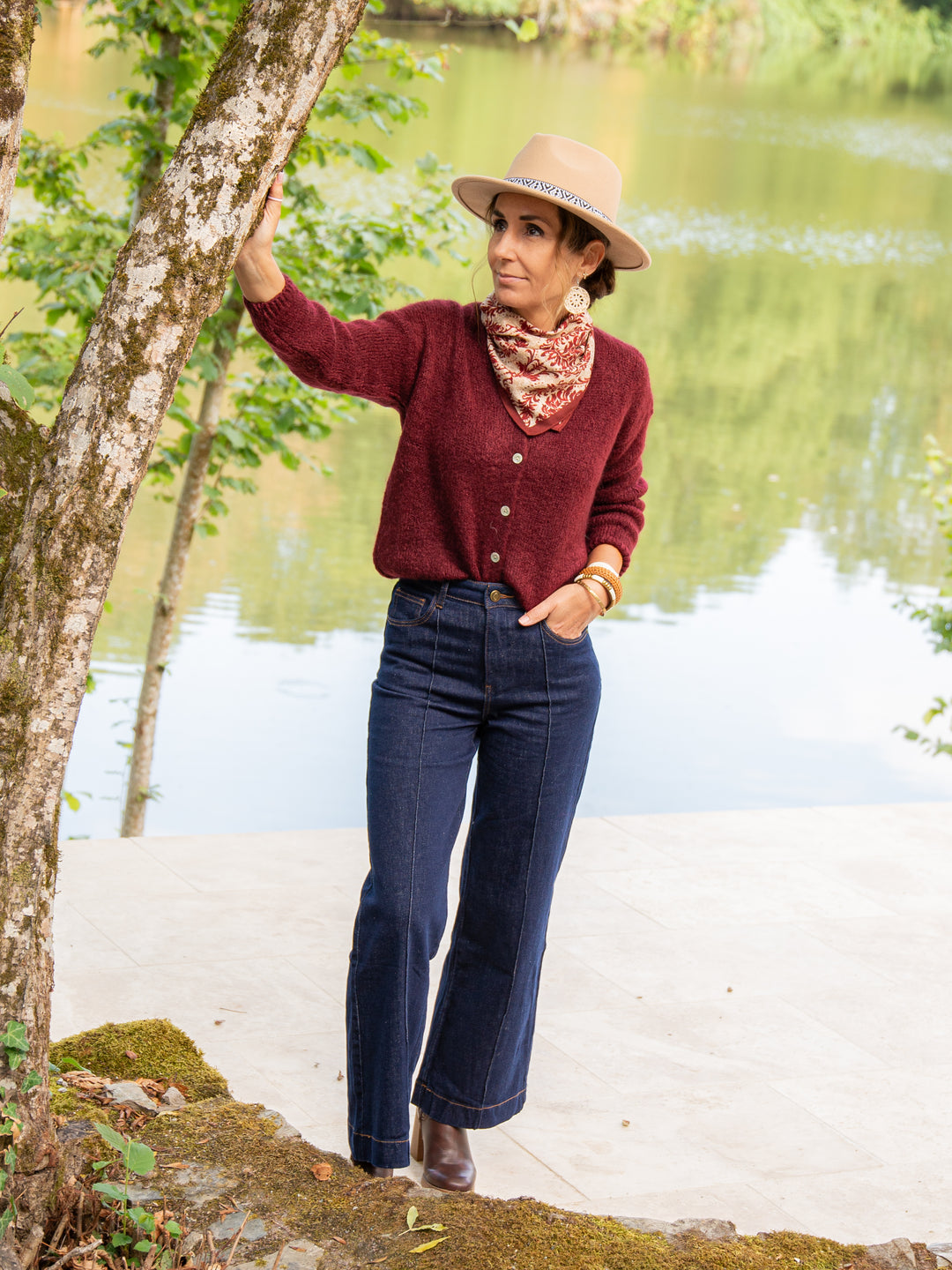 Gilet bordeaux femme porté avec un jean taille haute et chapeau beige tendance automne