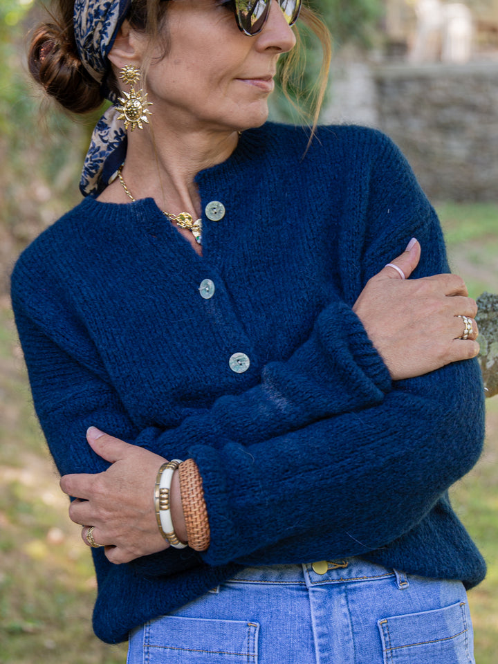 Gilet marine en laine avec boutons nacrés porté par une femme élégante