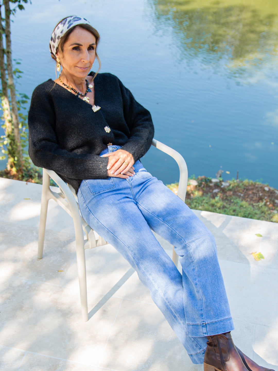 Gilet noir femme porté avec jean clair et bottines, look automne chic