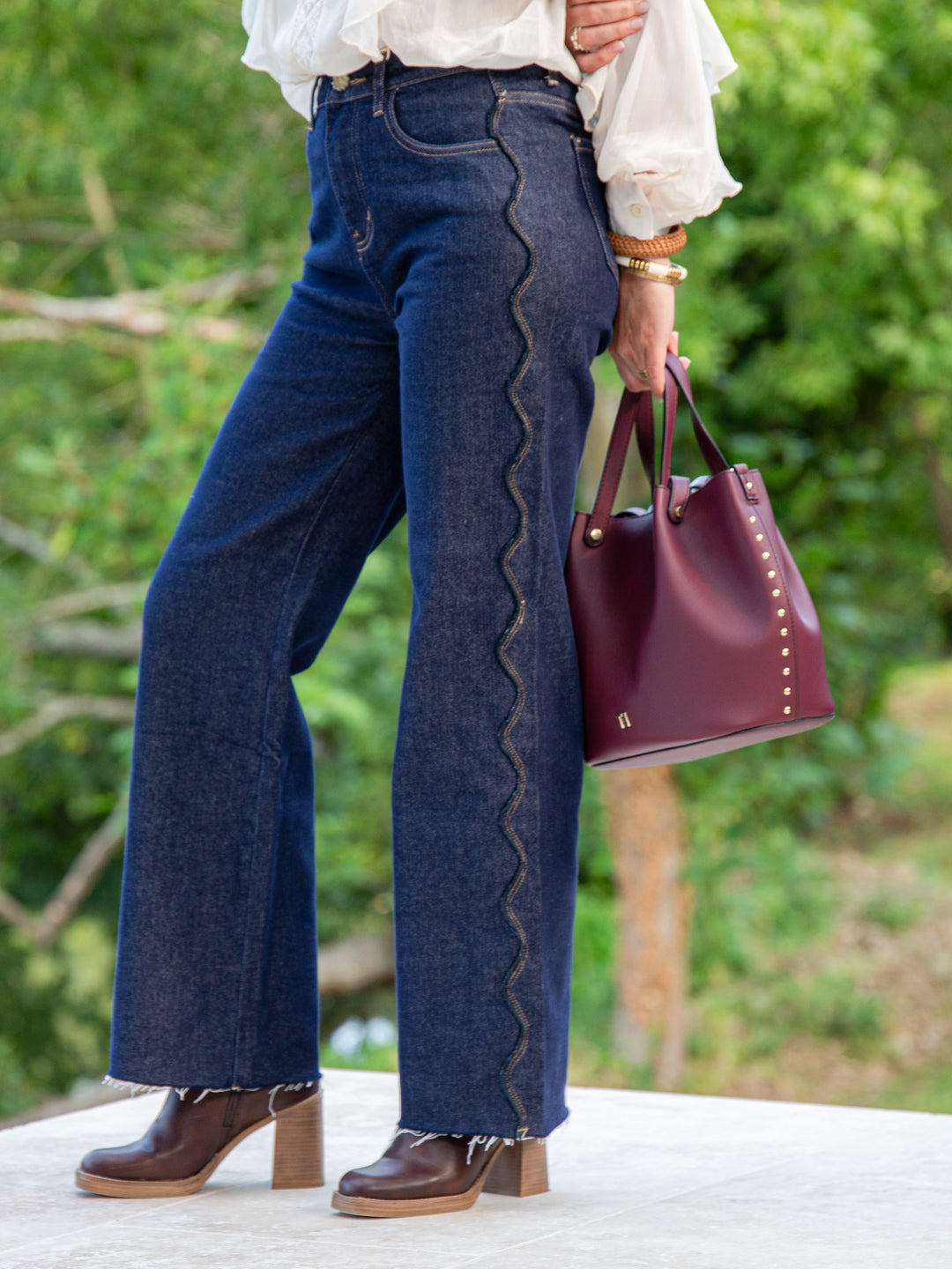 Zoom couture vague originale sur le côté du jean brut, détail mode unique pour femme