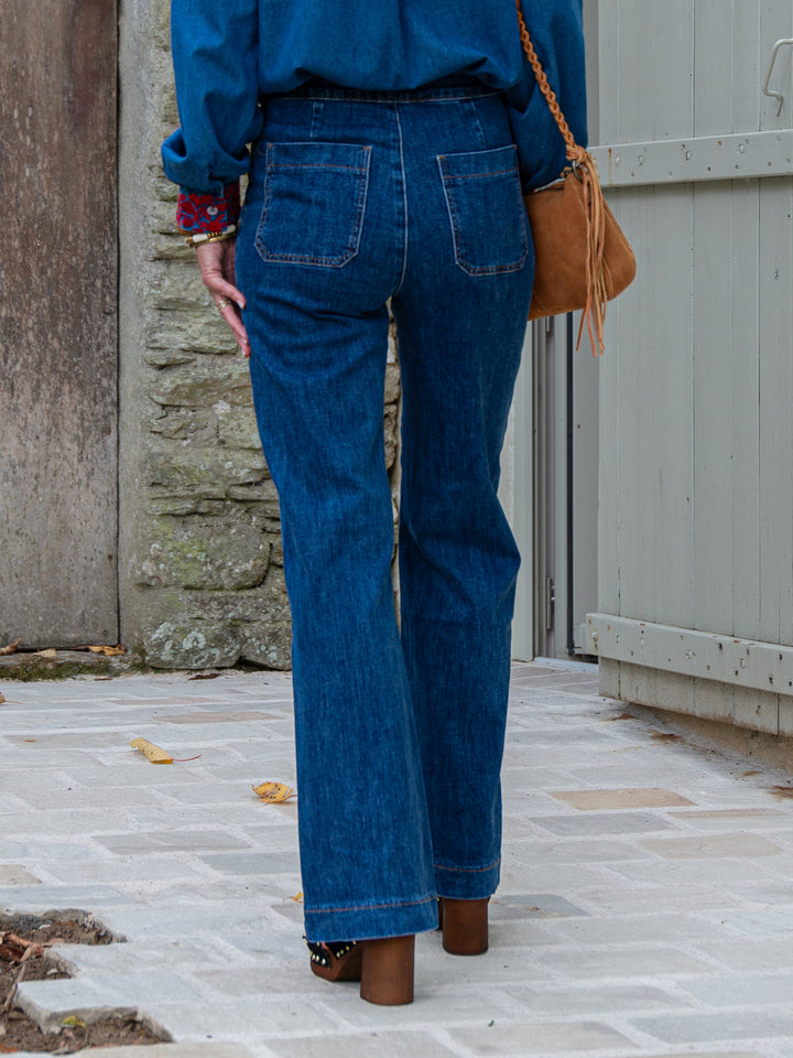vue de dos d’un jean Victo Oraije femme coupe flare en denim bleu brut