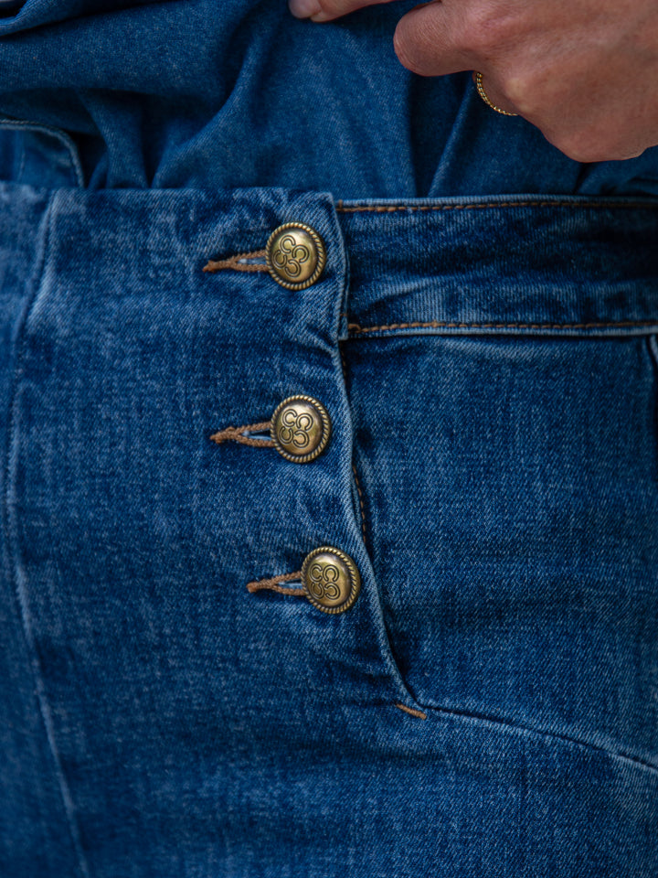 gros plan sur la taille haute d’un jean Victo Oraije femme avec boutons en métal doré
