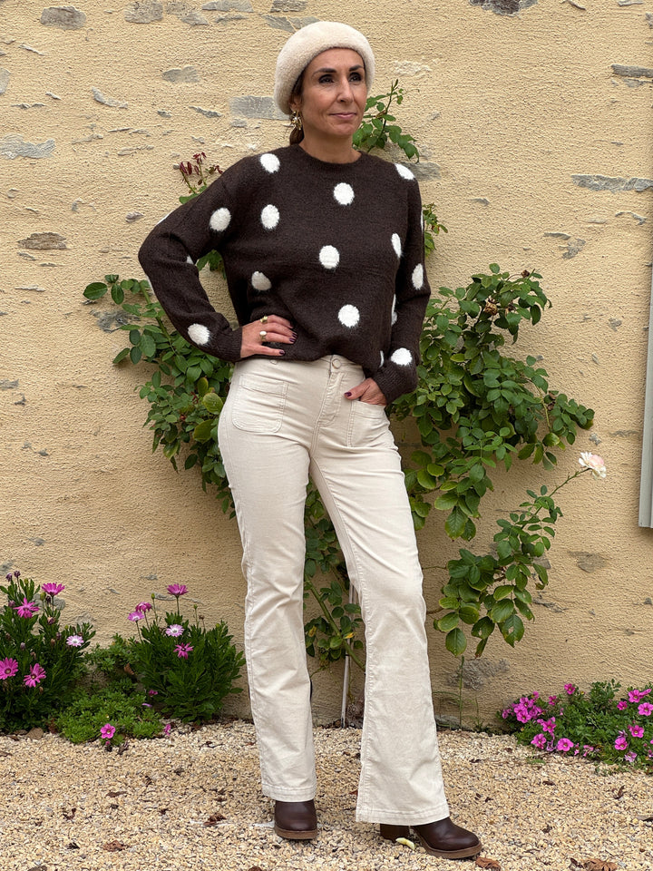 Pantalon écru en velours lisse SONNY La Petite Étoile pour femme, coupe évasée et taille haute, porté avec un pull marron à pois.
