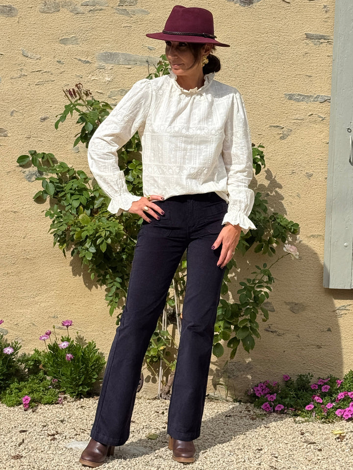 Pantalon marine en velours lisse SONNY La Petite Étoile pour femme, coupe évasée taille haute, porté avec une blouse écrue brodée.