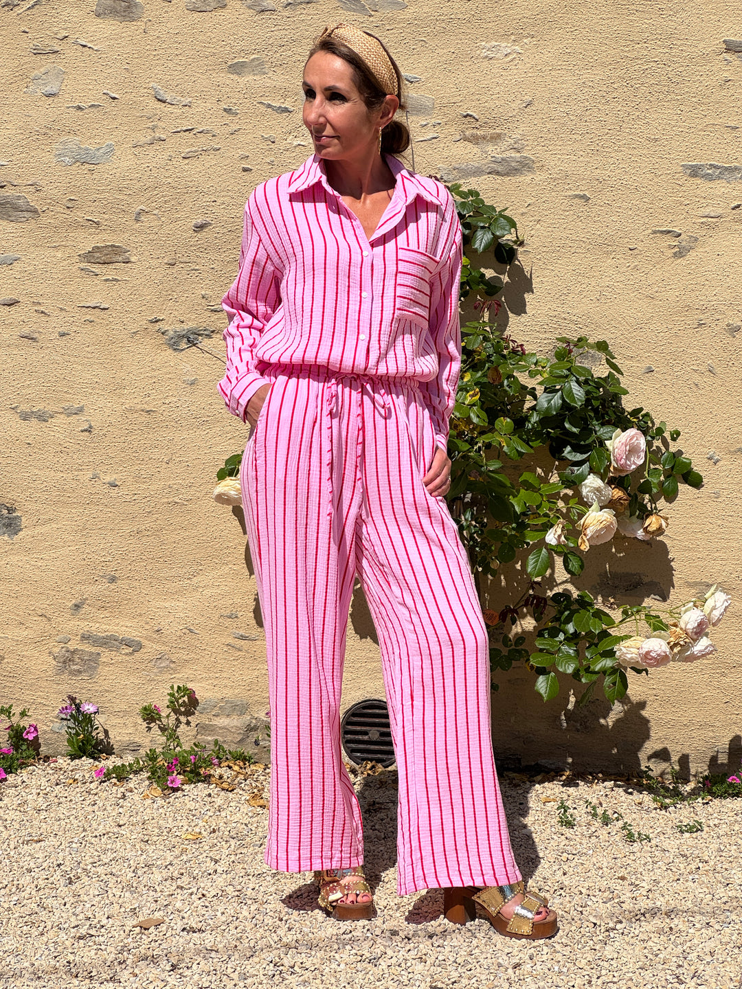 Pantalon à rayures roses et rouges, coupe longue fluide avec taille élastiquée, en effet gaze de coton légère et confortable, idéal pour l’été.