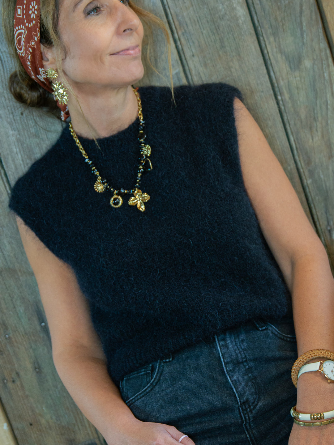 Pull sans manches noir femme look chic avec jean noir et bijoux dorés De La Mode