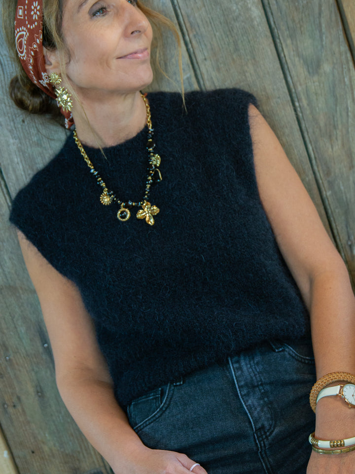 Pull sans manches noir femme look chic avec jean noir et bijoux dorés De La Mode