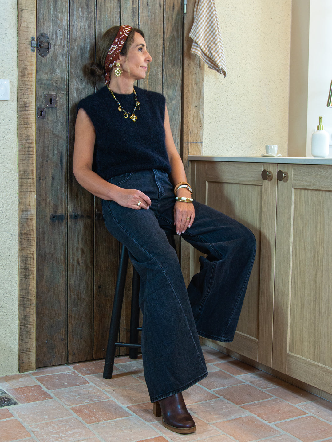 Pull sans manches noir femme tenue complète avec jean large et bottines De La Mode