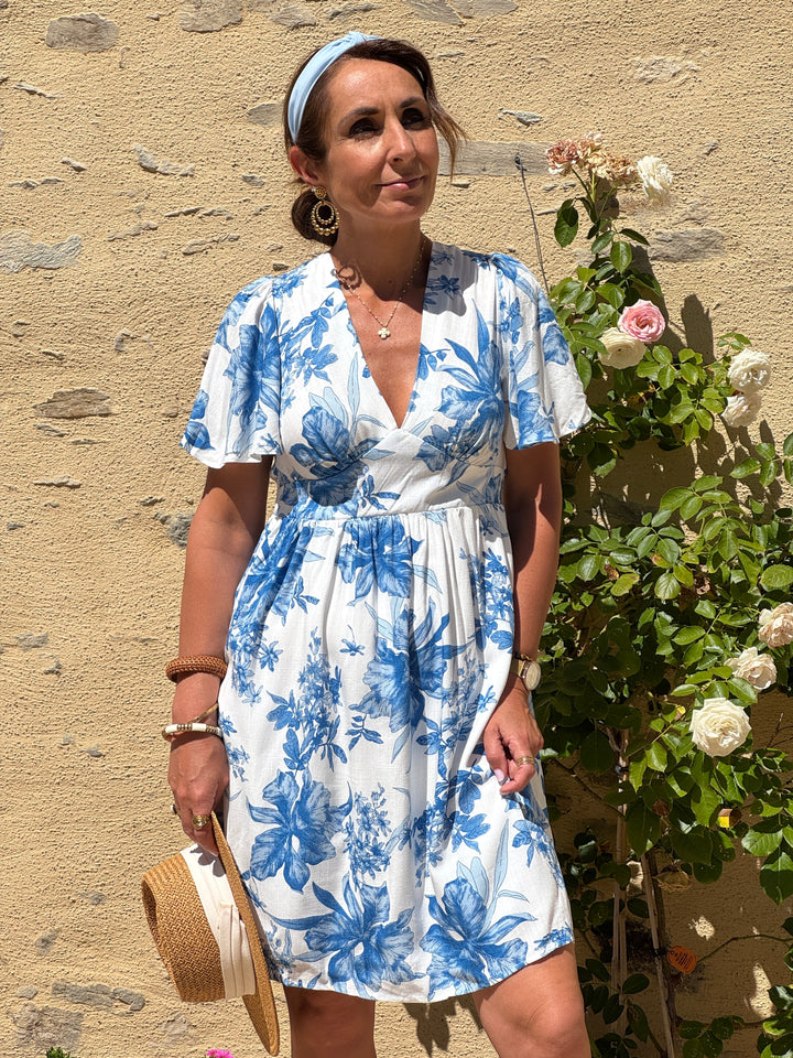 Robe courte In April 1986 à imprimé fleuri bleu sur fond blanc, coupe empire, col V et manches courtes.