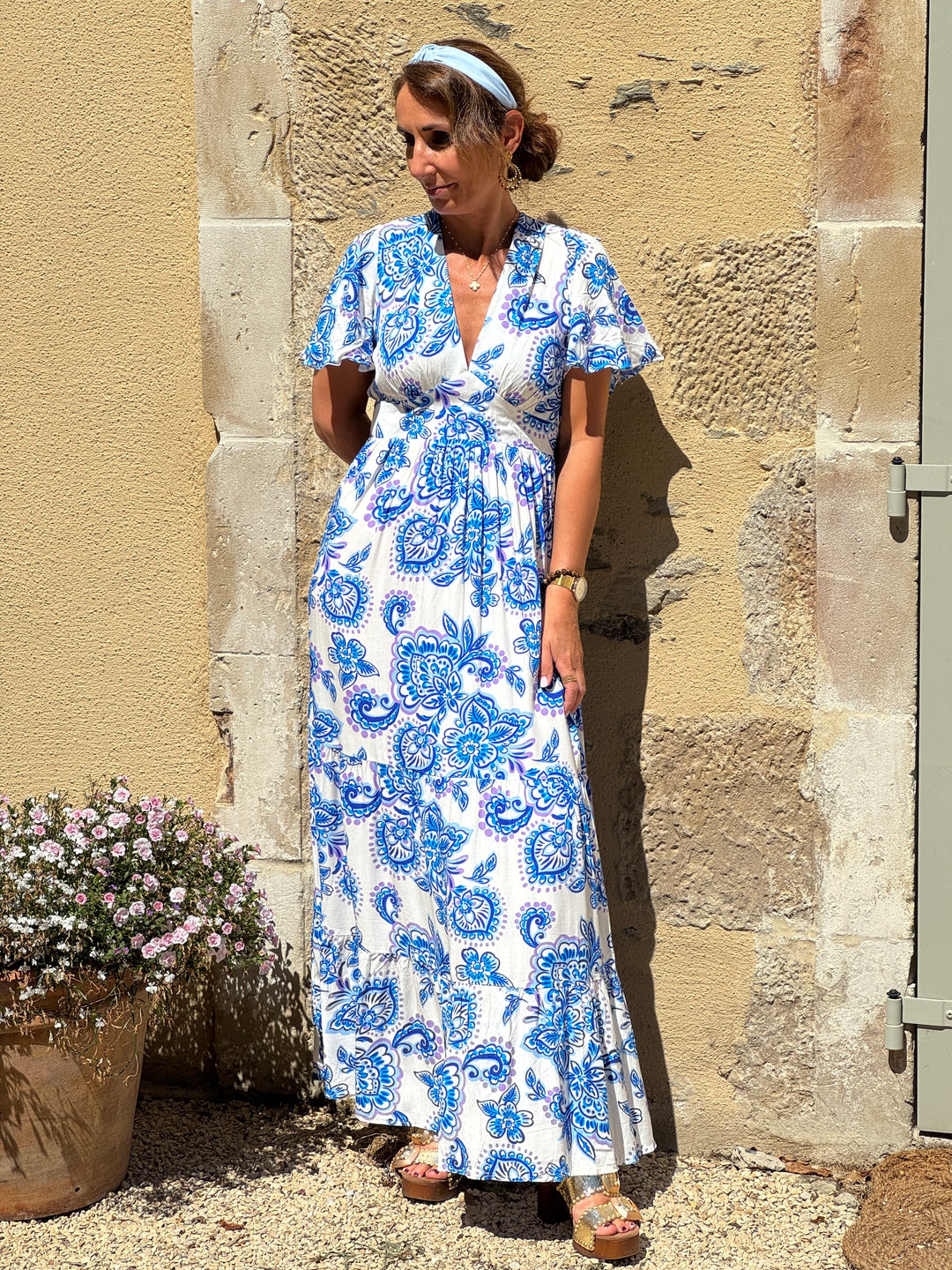 Robe longue In April 1986 à imprimé floral bleu sur fond blanc, coupe empire, col V et manches courtes.