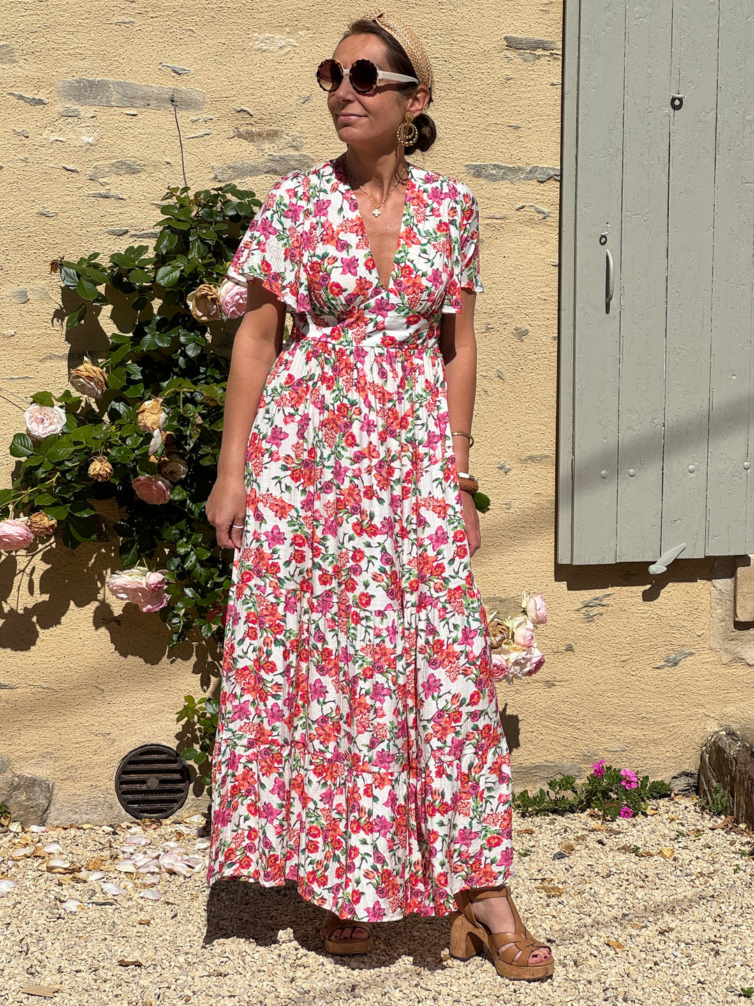 Robe longue écrue à imprimé floral rose, orange et vert, coupe empire avec col V devant et dos, manches courtes, fluide et légère, parfaite pour l’été.
