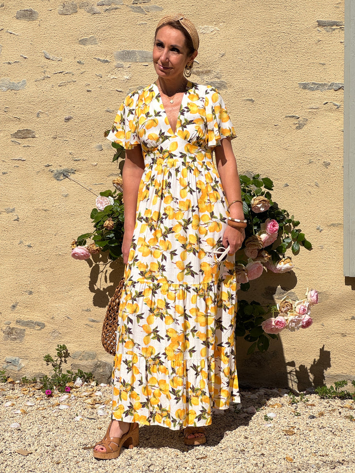 Robe longue écrue à imprimé citron jaune et vert, coupe empire avec col V devant et dos, manches courtes, fluide et légère, idéale pour un look frais et tendance d’été.