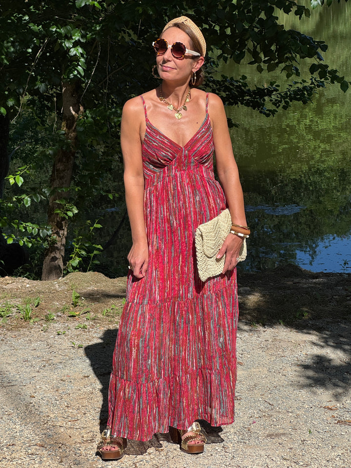 Robe longue rouge à imprimé multicolore avec touches de vert, bleu et doré, coupe empire et fines bretelles réglables. Une robe fluide et légère idéale pour l’été.