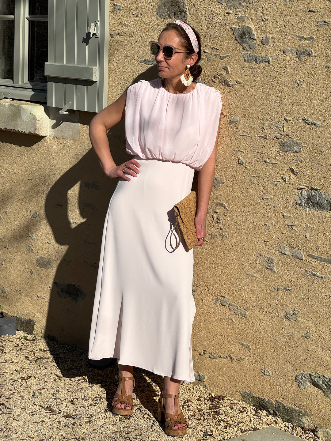Robe longue rose coupe empire avec drapé sur le haut, col rond sans manches et fente sur le bas, matière effet crêpe fluide pour un look estival chic