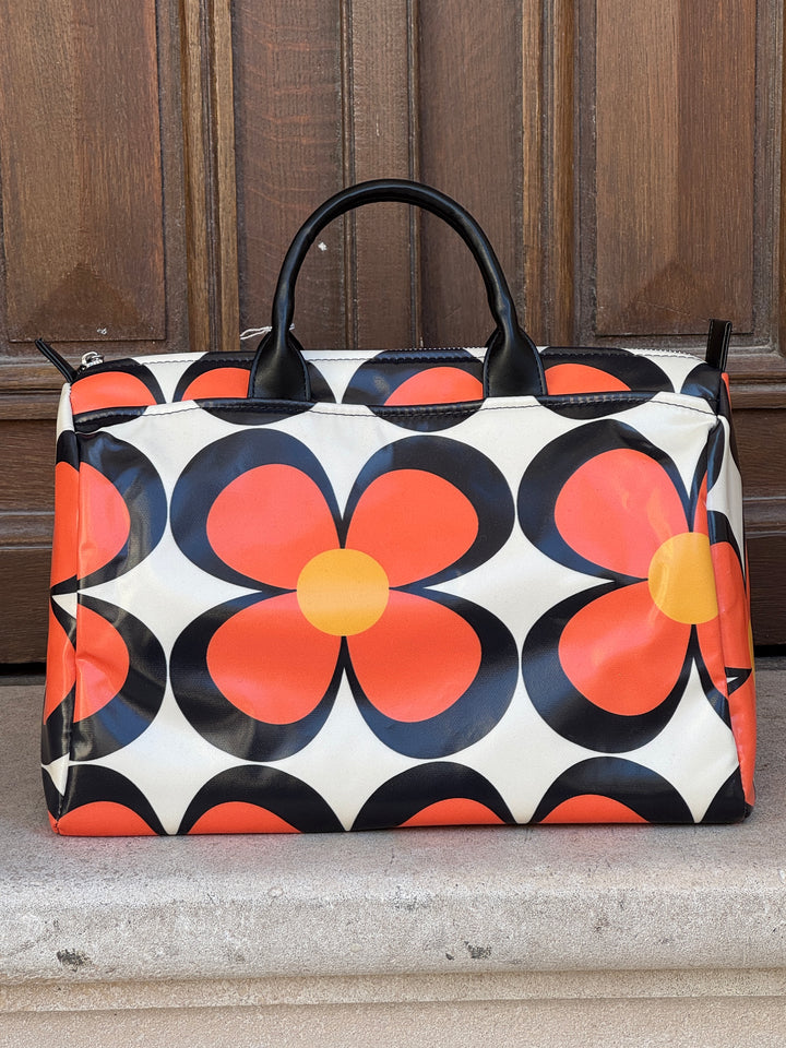 Sac bowling 107 Hippocampe imprimé rétro coloré à marguerites orange et noir sur fond écru, porté à la main