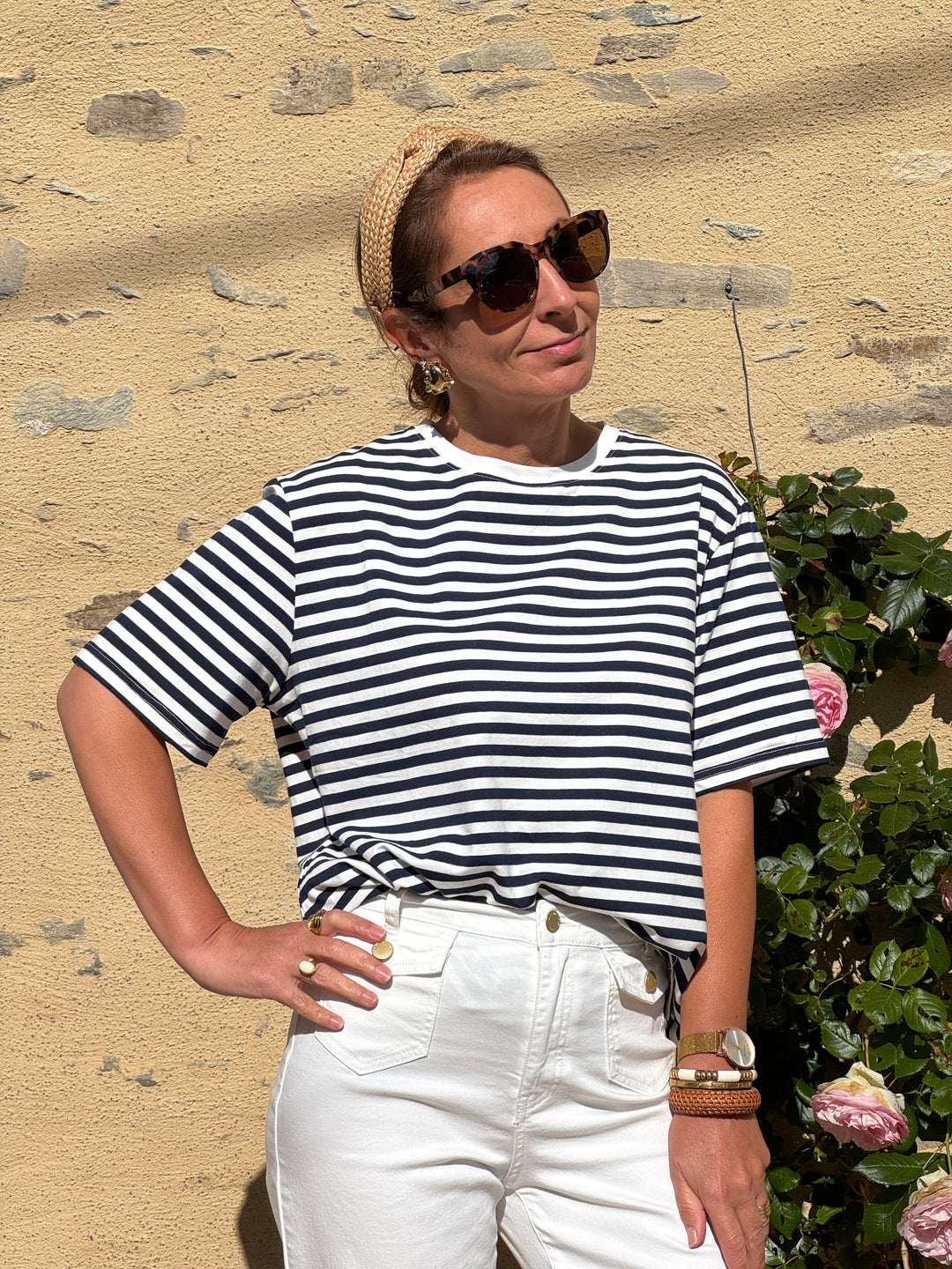 Tee-shirt marinière en coton à rayures bleu marine sur fond blanc, manches courtes et coupe droite, style décontracté et moderne idéal pour l’été.