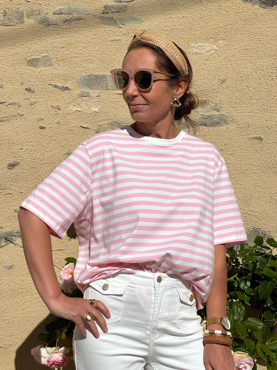 Tee-shirt style marinière en coton avec rayures roses sur fond blanc, manches courtes et coupe droite confortable, parfait pour un look casual et tendance pendant l’été.
