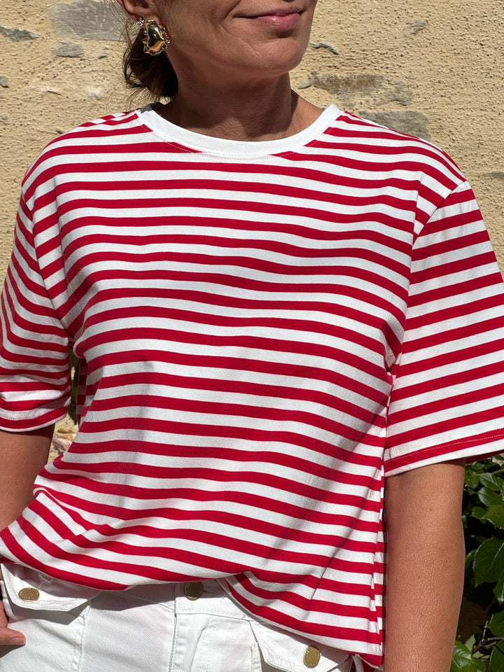 Tee-shirt marinière en coton à rayures rouges sur fond blanc, manches courtes et coupe droite, style moderne et décontracté idéal pour un look d’été.