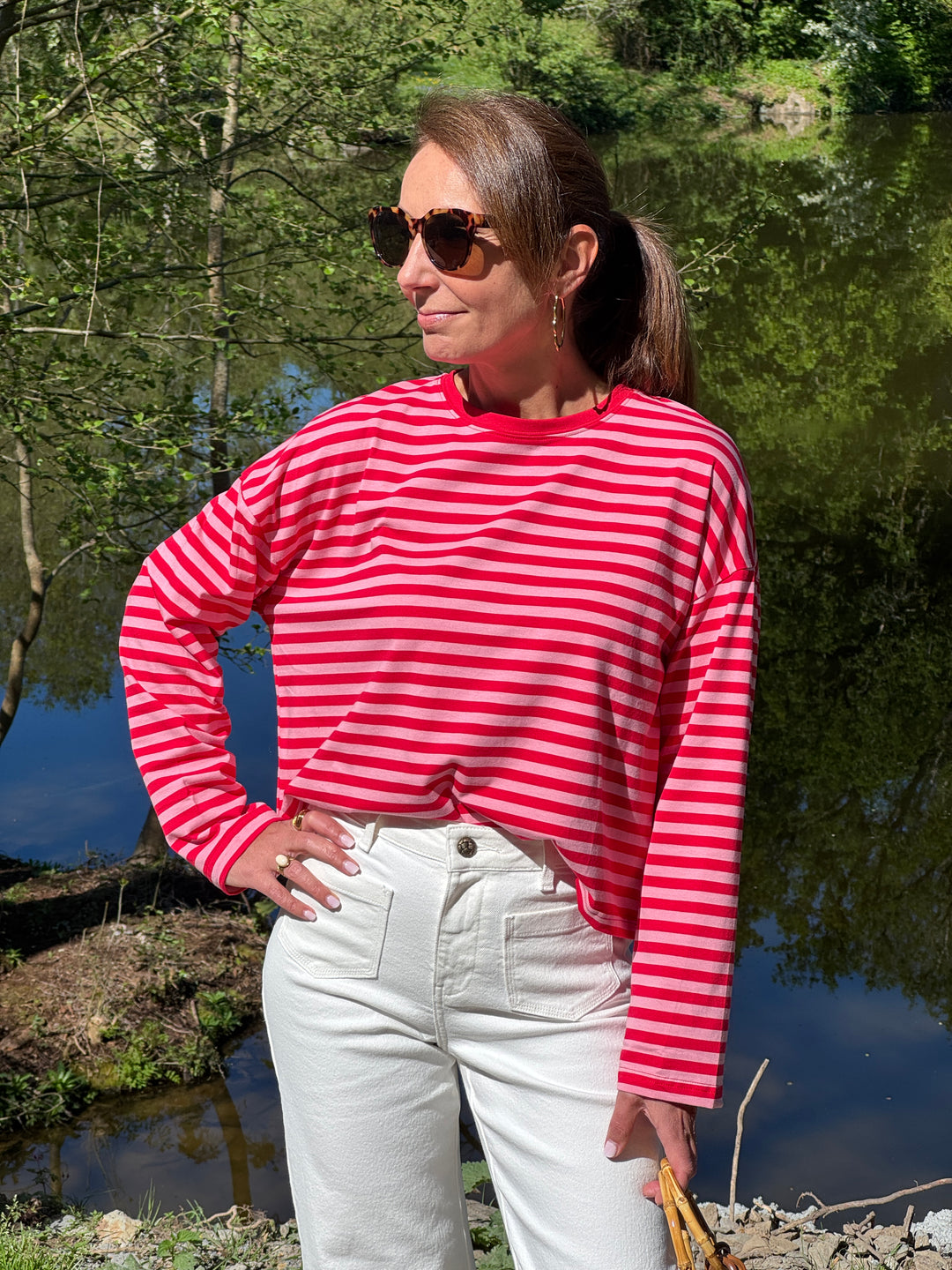 Tee-shirt marinière rouge sur fond rose manches longues coupe oversize avec col rond pour un look moderne idéal mi-saison