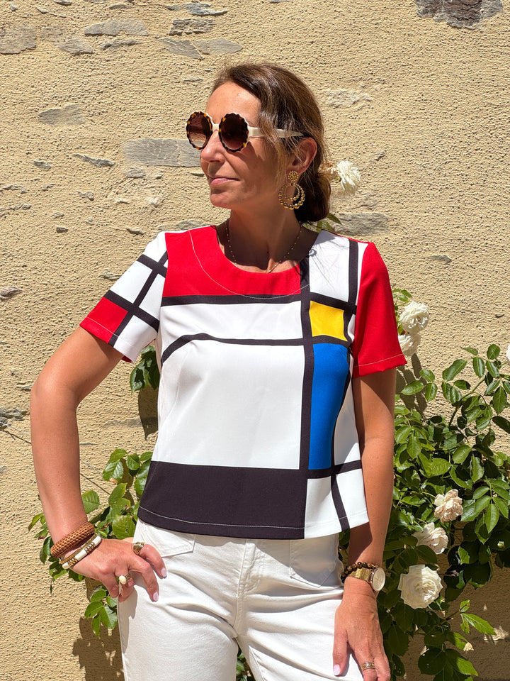 Top Mondrian Hippocampe à imprimé géométrique rouge, jaune, bleu, noir et blanc, coupe trapèze, col rond et manches courtes.