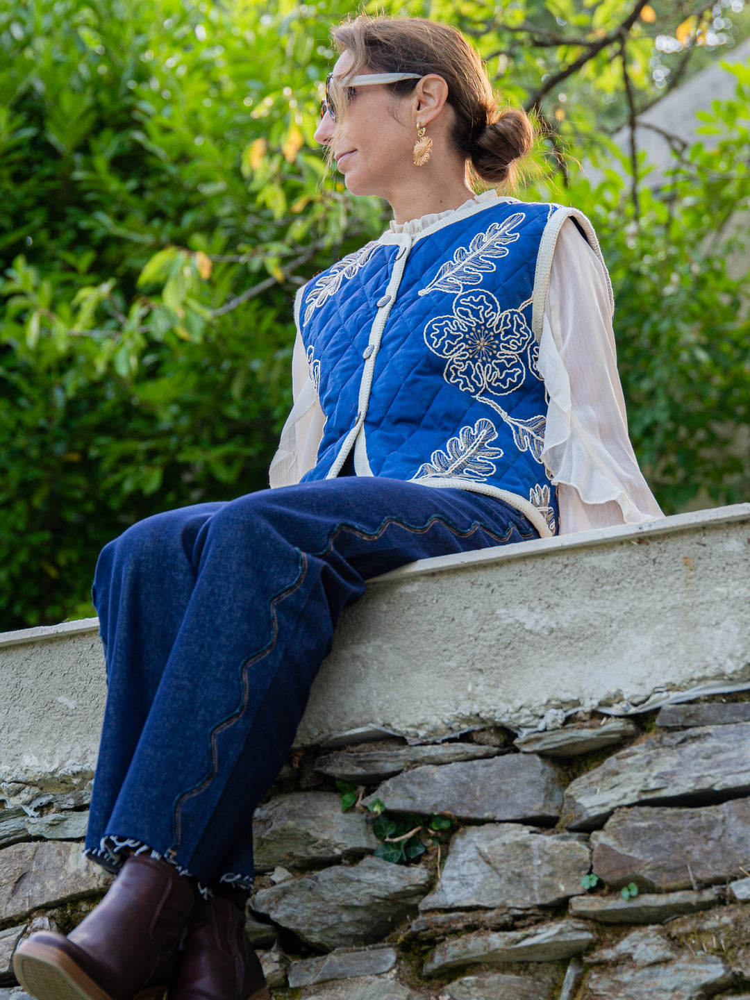 Look bohème avec veste sans manche matelassée bleu brodée portée sur une chemise fluide